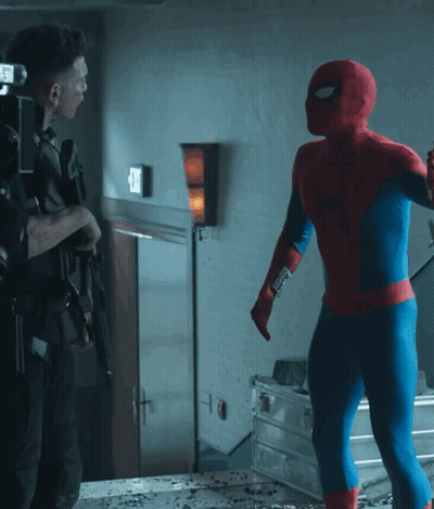 A Man In A Spiderman Costume Stands Next To A Man In A Black Suit GIF