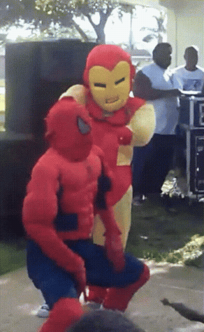 A Man In A Spiderman Costume Stands Next To A Man In An Ironman Costume GIF