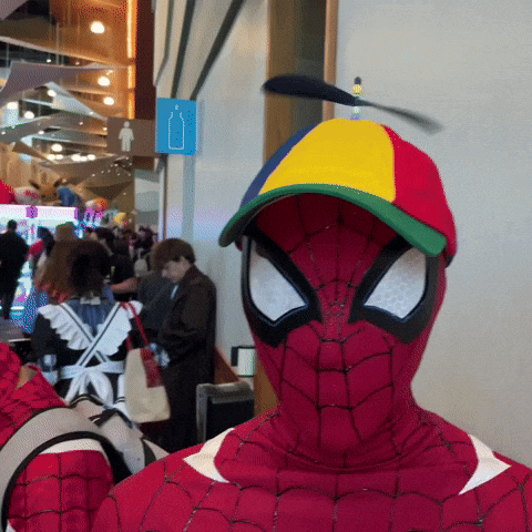 A Man In A Spiderman Costume With A Colorful Hat On GIF