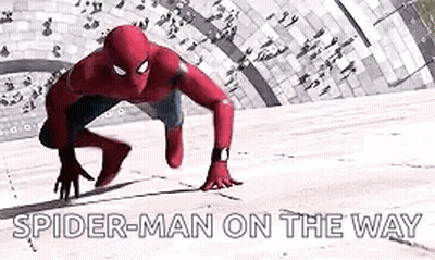 A Man In A Spiderman Suit Is Crawling On The Ground . GIF