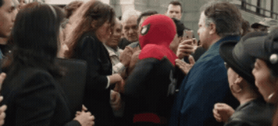 A Man In A Spiderman Suit Is Surrounded By People GIF