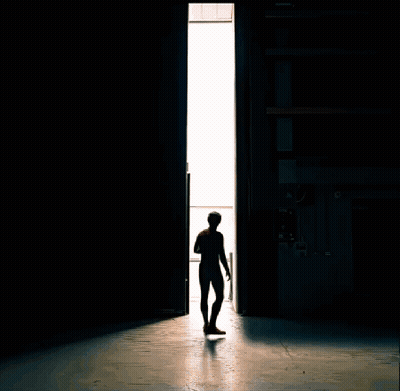 A Man In A Spiderman Suit Stands In Front Of A Door GIF