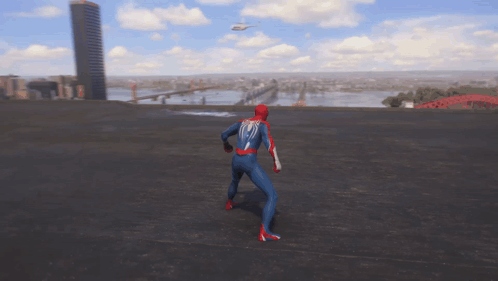 A Man In A Spiderman Suit Stands On A Rooftop With A Helicopter Flying In The Background GIF