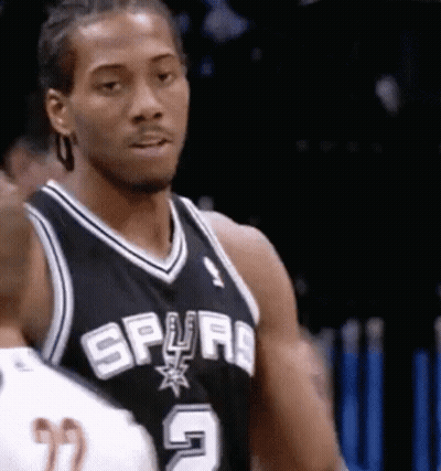 A Man In A Spurs Jersey Is Looking At Something GIF