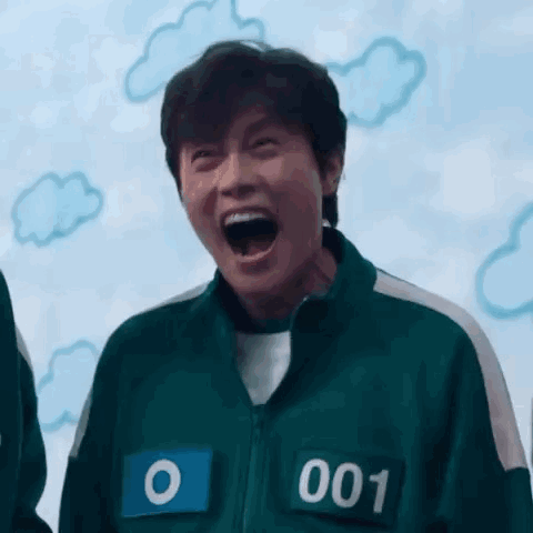 A Man In A Squid Game Uniform Is Laughing With His Mouth Wide Open . GIF