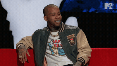 A Man In A Srf Sex Shirt Sits On A Couch GIF
