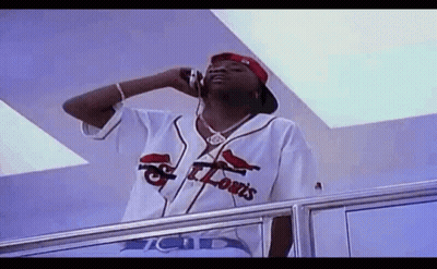 A Man In A St. Louis Baseball Jersey Is Talking On A Cell Phone . GIF