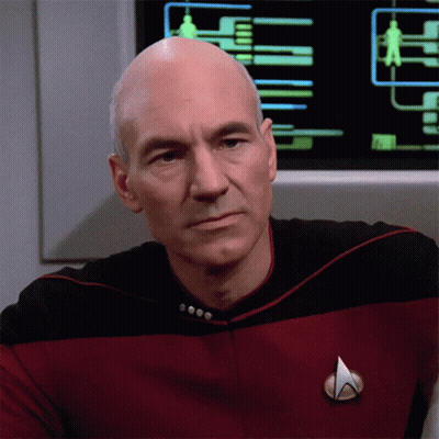 A Man In A Star Trek Uniform Has A Badge On His Chest GIF