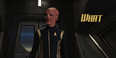 A Man In A Star Trek Uniform Is Standing In A Hallway With The Words What Is It You So Urgently Need My Help With GIF