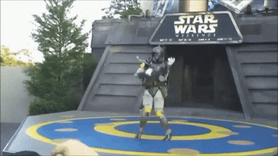 A Man In A Star Wars Costume Is Standing In Front Of A Sign That Says Star Wars Weekends GIF