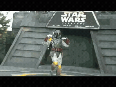 A Man In A Star Wars Costume Is Standing In Front Of A Star Wars Weekends Sign GIF