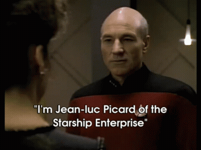A Man In A Starship Enterprise Uniform Talks To Another Man GIF