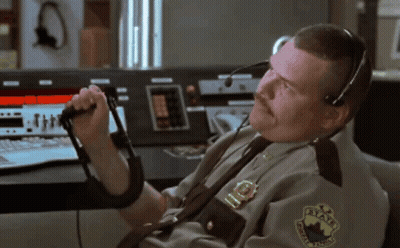 A Man In A State Trooper Uniform Is Talking On A Walkie Talkie GIF