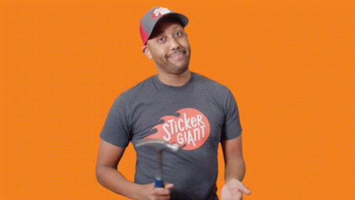 A Man In A Sticker Giant T-Shirt Holds A Hammer GIF