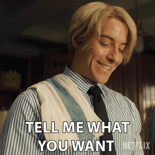 A Man In A Striped Shirt And Tie Is Smiling And Saying Tell Me What You Want GIF