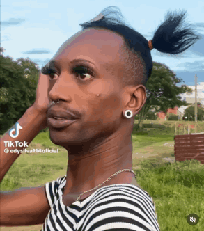 A Man In A Striped Shirt Has A Ponytail And A Nose Ring GIF