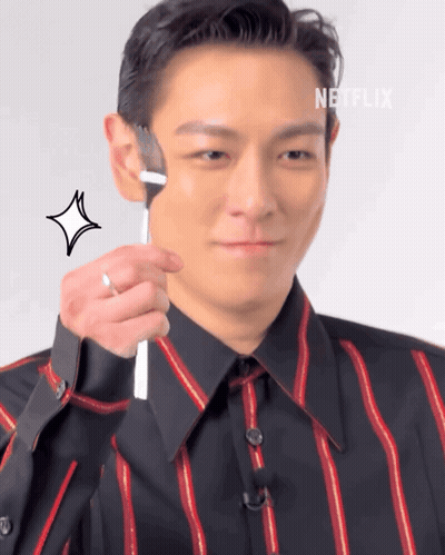 A Man In A Striped Shirt Holds A Fork To His Face GIF