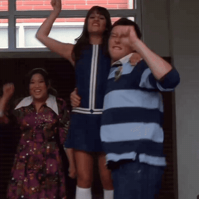 A Man In A Striped Shirt Holds A Woman In A Blue Dress In His Arms GIF