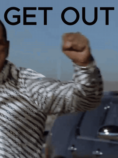 A Man In A Striped Shirt Holds Up His Fist In Front Of A Sign That Says Get Out GIF
