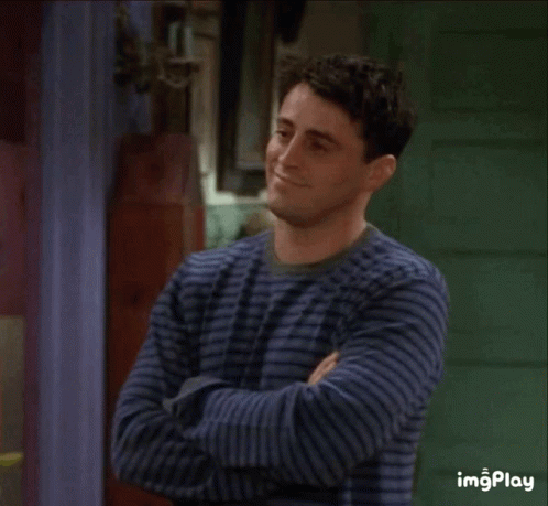 A Man In A Striped Shirt Is Covering His Nose With His Hand GIF