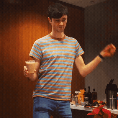 A Man In A Striped Shirt Is Holding A Cone GIF