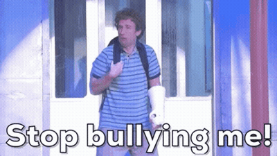 A Man In A Striped Shirt Is Holding A Megaphone And Saying Stop Bullying Me GIF