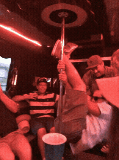 A Man In A Striped Shirt Is Holding A Pole In A Red Room GIF