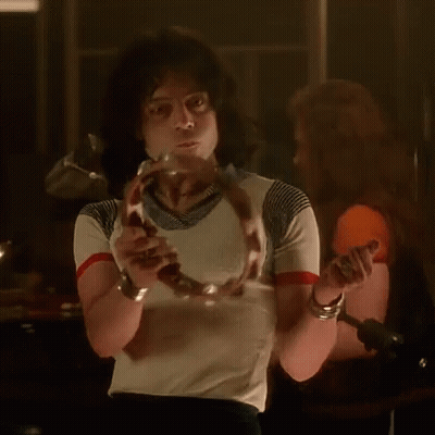 A Man In A Striped Shirt Is Holding A Snake In His Hand GIF