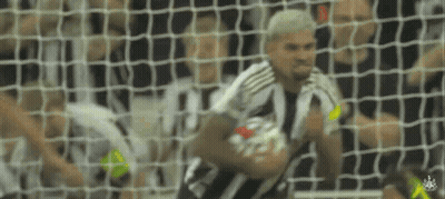 A Man In A Striped Shirt Is Holding A Soccer Ball In Front Of A Goal Net . GIF