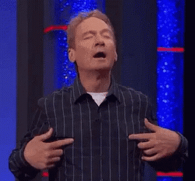 A Man In A Striped Shirt Is Holding His Hands To His Chest And Pointing At His Chest . GIF
