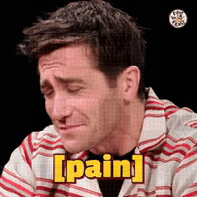 A Man In A Striped Shirt Is Making A Face And Saying Pain . GIF