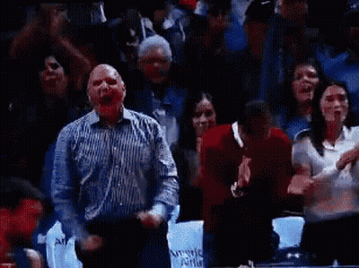 A Man In A Striped Shirt Is Screaming In A Crowd Of People While Holding A Sign That Says Award Able GIF