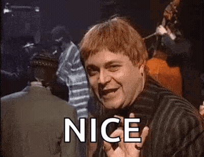A Man In A Striped Shirt Is Smiling And Waving At The Camera With The Word Nice . GIF