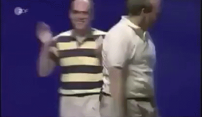 A Man In A Striped Shirt Is Standing Next To A Man In A White Shirt GIF