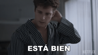 A Man In A Striped Shirt Says Esta Bien In White Letters GIF