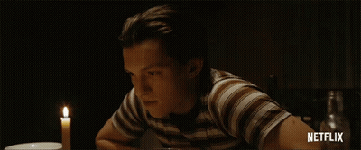 A Man In A Striped Shirt Sits At A Table With A Candle And Says Netflix On The Bottom Right GIF