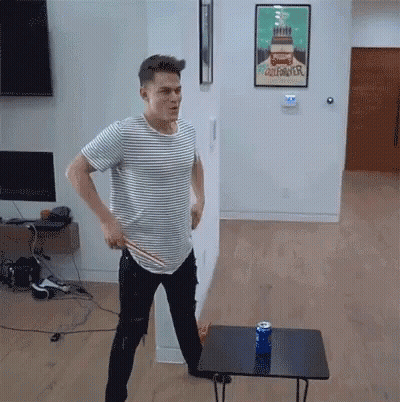 A Man In A Striped Shirt Stands In Front Of A Poster That Says California GIF