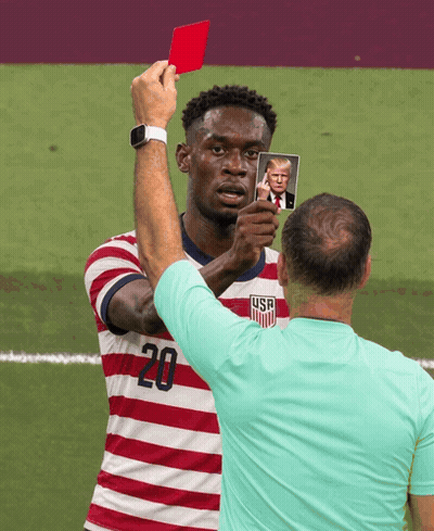 A Man In A Striped Shirt With The Number 20 On It Holds Up A Picture Of Donald Trump GIF