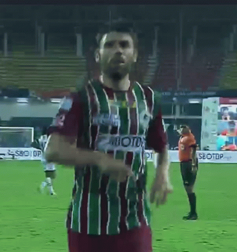 A Man In A Striped Shirt With The Number 3 On It Is Standing On A Soccer Field . GIF