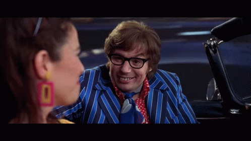 A Man In A Striped Suit And Tie Is Talking To A Woman In A Car And The Caption Says Oh Behave . GIF