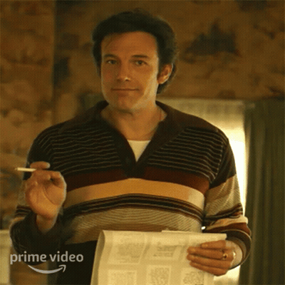 A Man In A Striped Sweater Is Holding A Newspaper And A Cigarette In His Hand . GIF