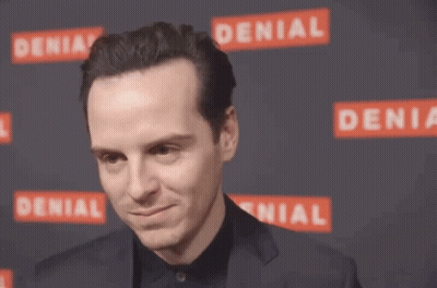 A Man In A Suit Adjusts His Hair In Front Of A Denial Sign GIF