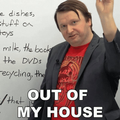 A Man In A Suit And A Red Shirt Stands In Front Of A White Board That Says " Out Of My House " GIF