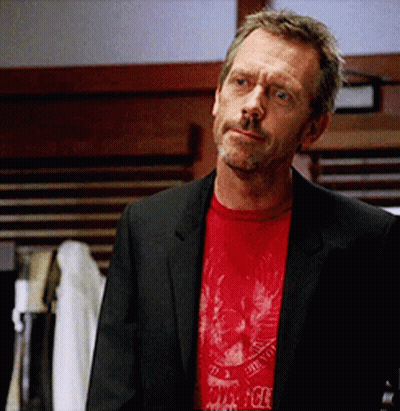 A Man In A Suit And A Red T-Shirt With A Skull And Crossbones On It GIF