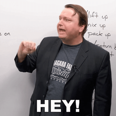 A Man In A Suit And A Shirt That Says " Hey " On It GIF
