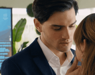 A Man In A Suit And A Woman In A White Shirt Are Touching Each Other GIF