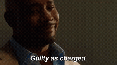 A Man In A Suit And Blue Shirt Is Smiling And Says Guilty As Charged GIF
