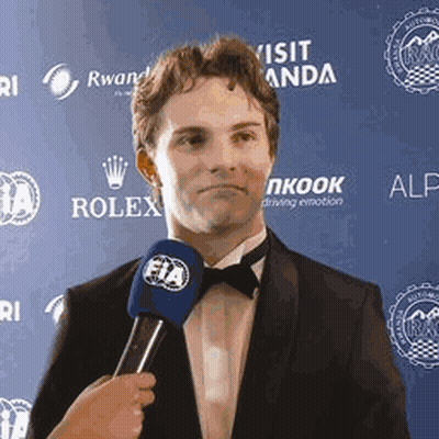 A Man In A Suit And Bow Tie Is Being Interviewed By A Woman Holding A Microphone . GIF