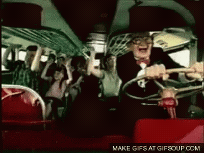 A Man In A Suit And Bow Tie Is Driving A Bus With A Crowd Of People . GIF