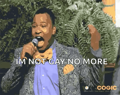 A Man In A Suit And Bow Tie Is Singing Into A Microphone And Saying `` Im Not Gay No More '' . GIF